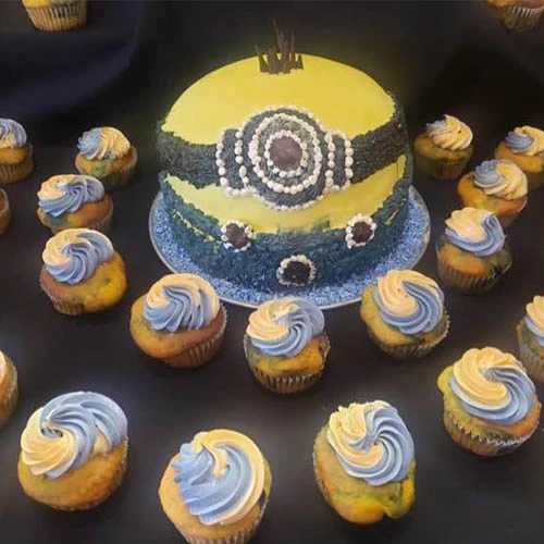 A minions cake with corresponding cupcakes decorated with blue and yellow.