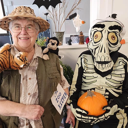 Residents dressed in halloween costumes. One is dressed as a zookeeper, the other as a skeleton.