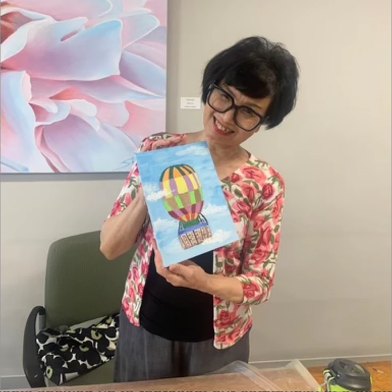 Senior standing with her painting