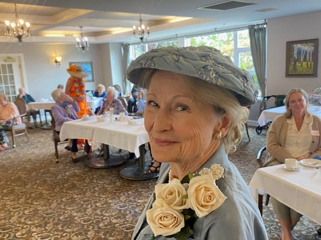 Female senior wearing a vintage blue dress adorned with white roses