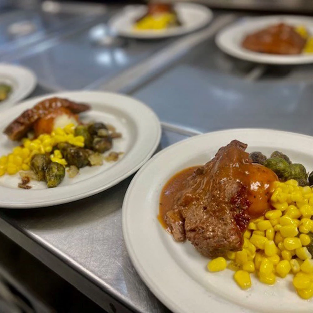 plates with roast, corn, brussel sprouts, and potatoes with gravy