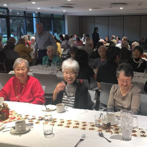 Residents enjoying Thanksgiving today together. Three women are smiling together at the first table.